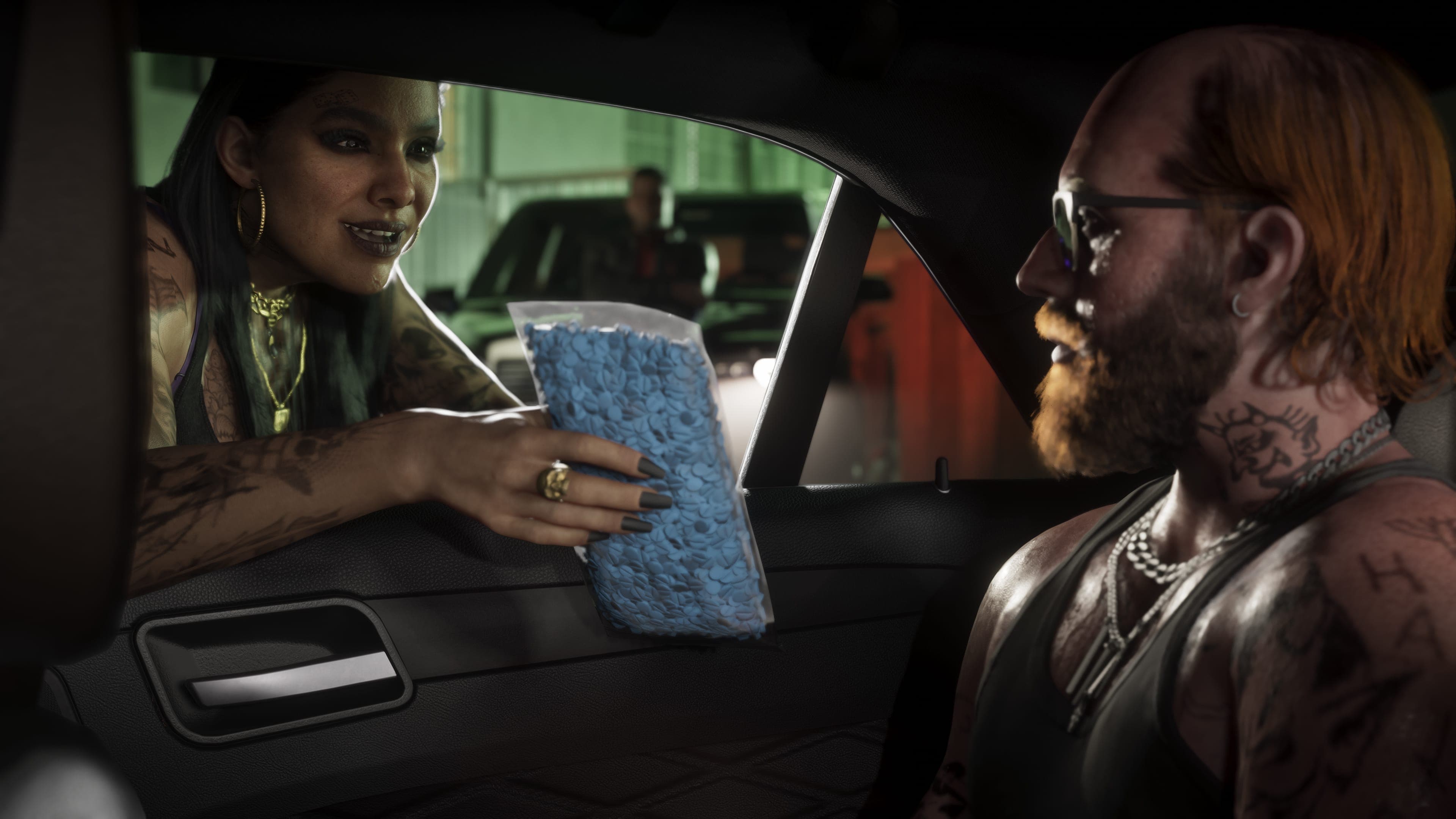 A woman in the passenger seat handing a wrapped package across to a tattooed driver