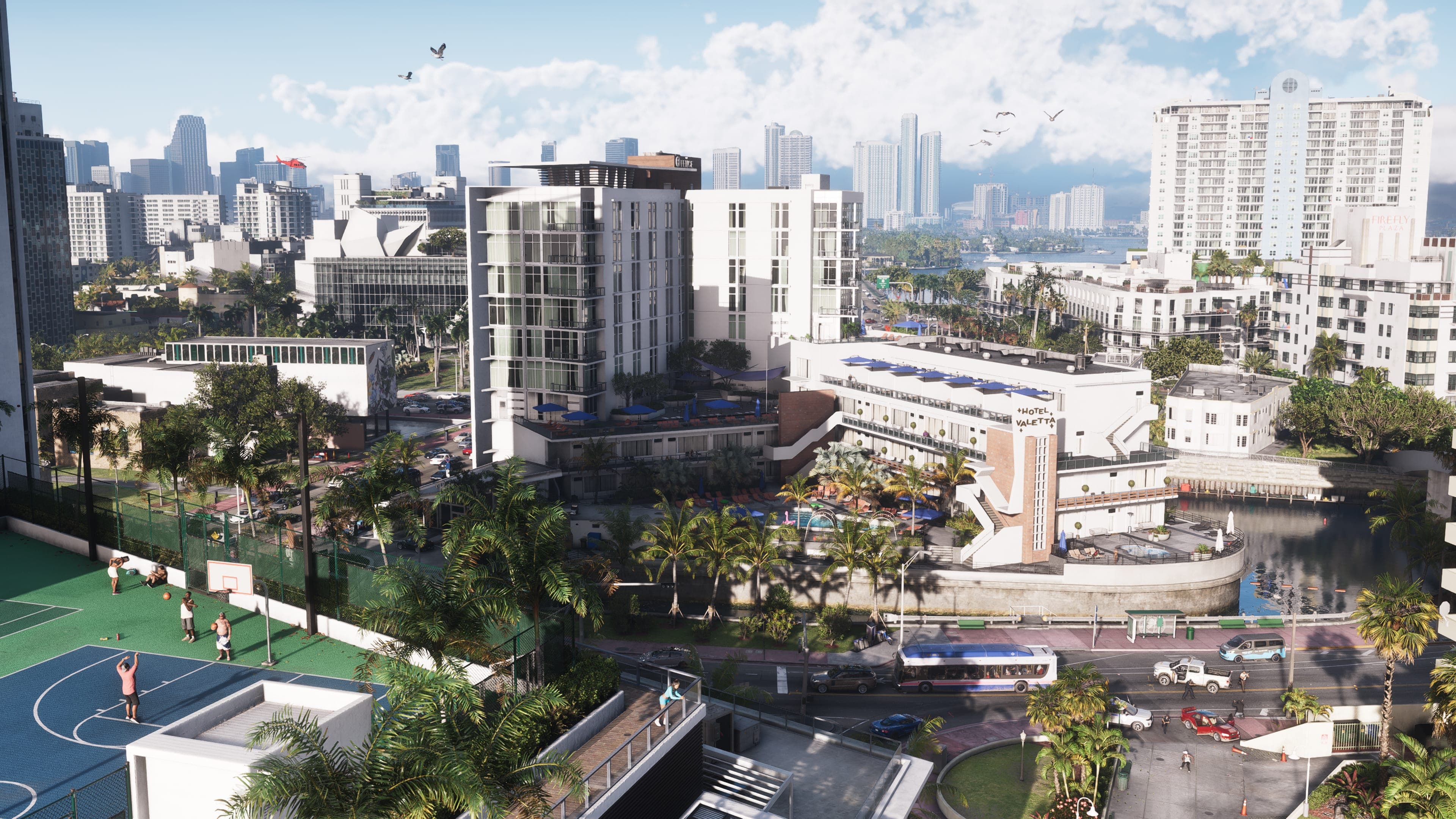 Daytime aerial of Vice City: white apartment blocks, a rooftop basketball court, and the downtown skyline in haze behind