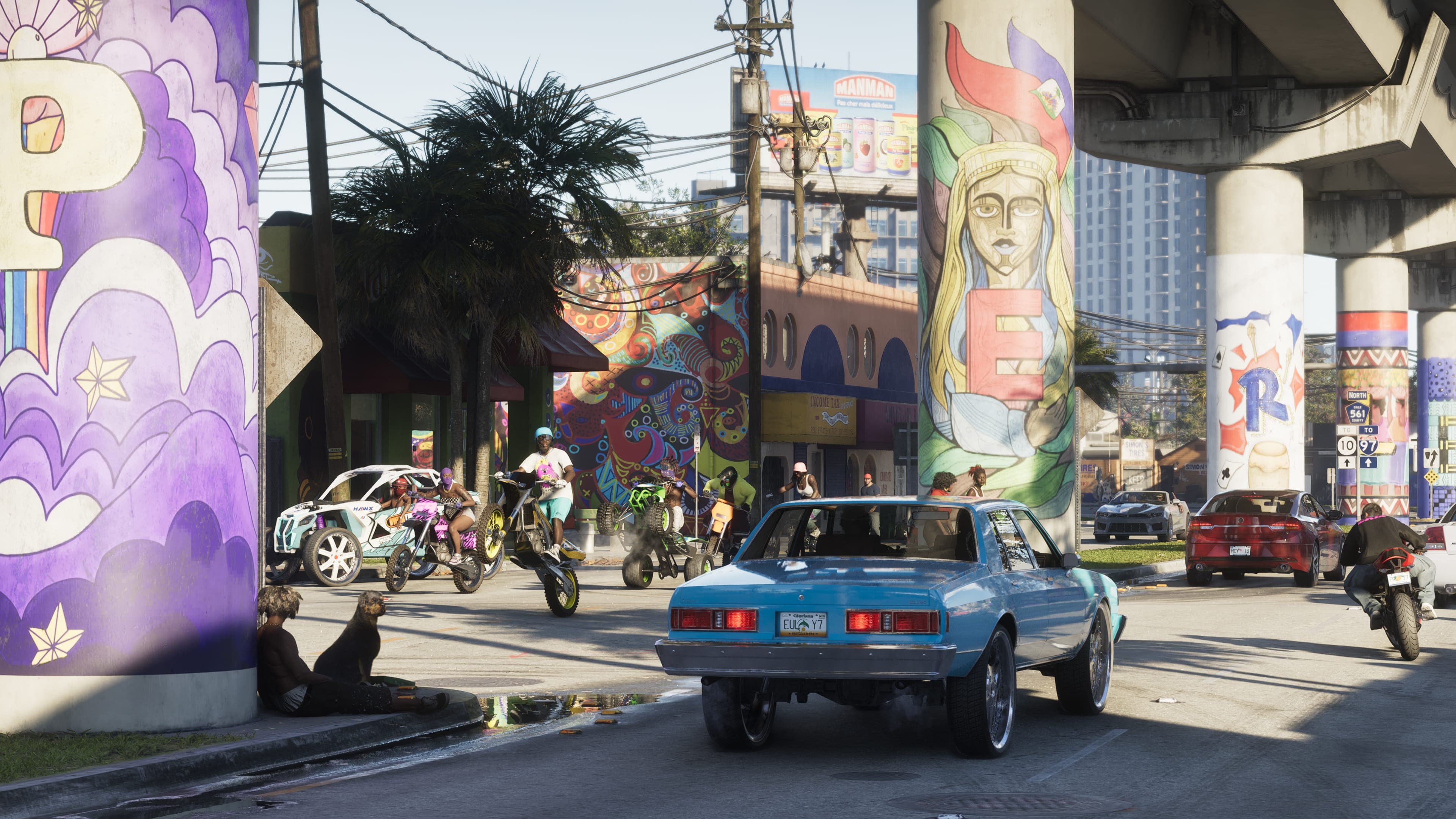 A blue muscle car and a motorbike passing painted mural columns under a Vice City overpass