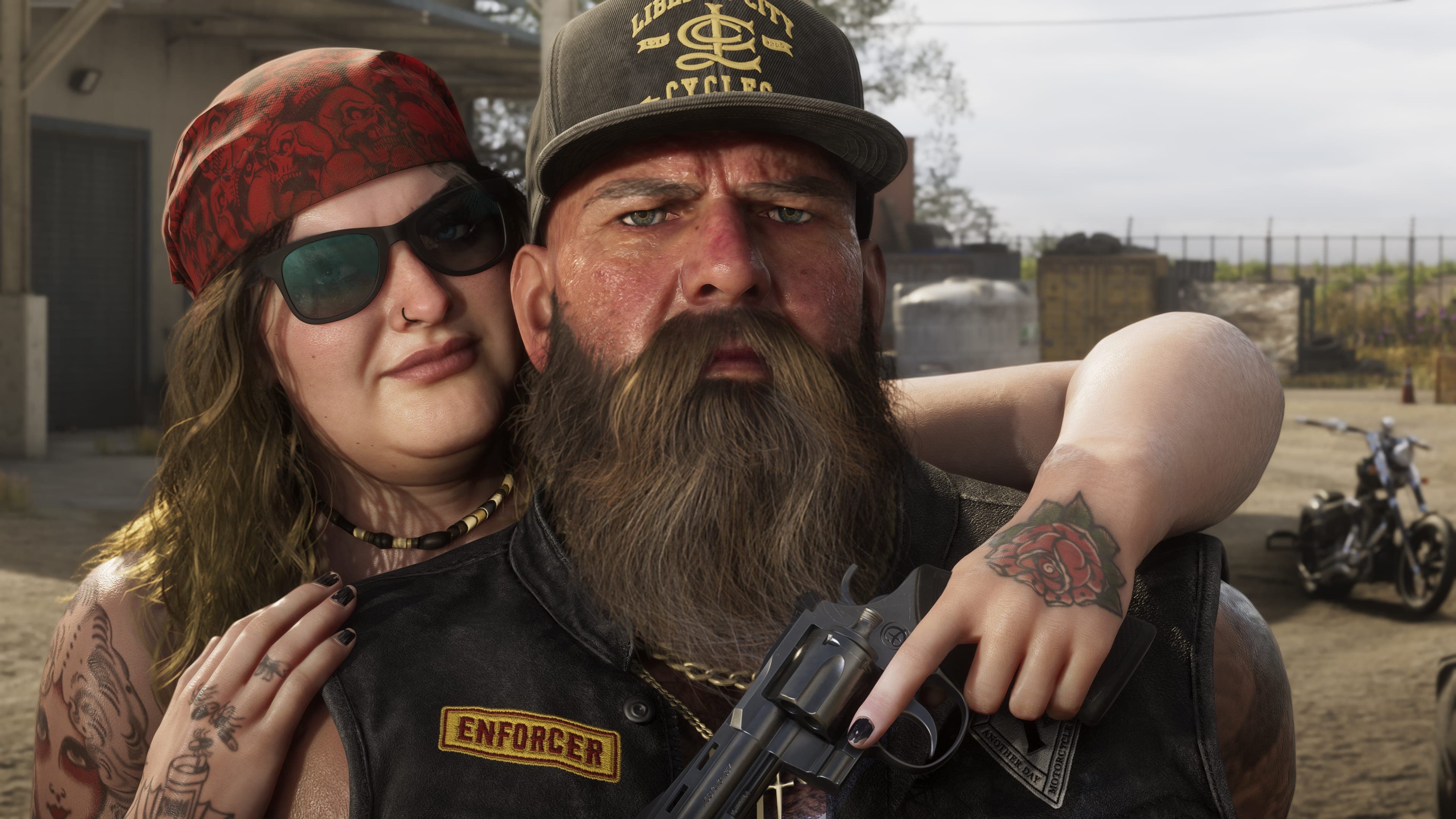 Close portrait of a biker couple, the man wearing an Enforcer patch and the woman a red bandana