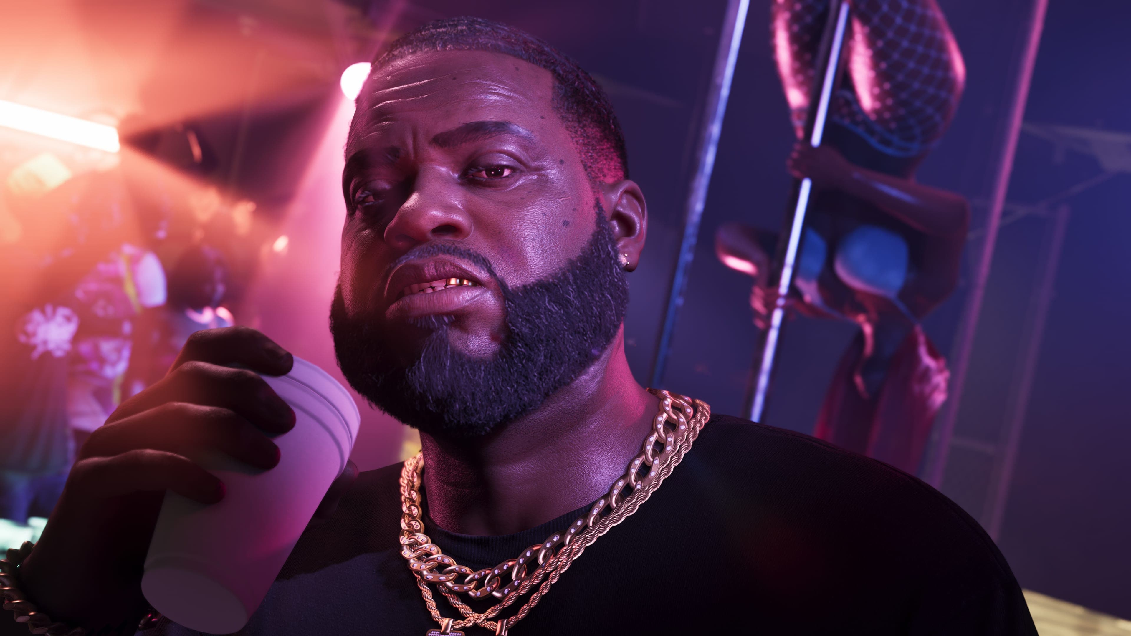 Close portrait of Boobie Ike holding a drink under pink club lighting