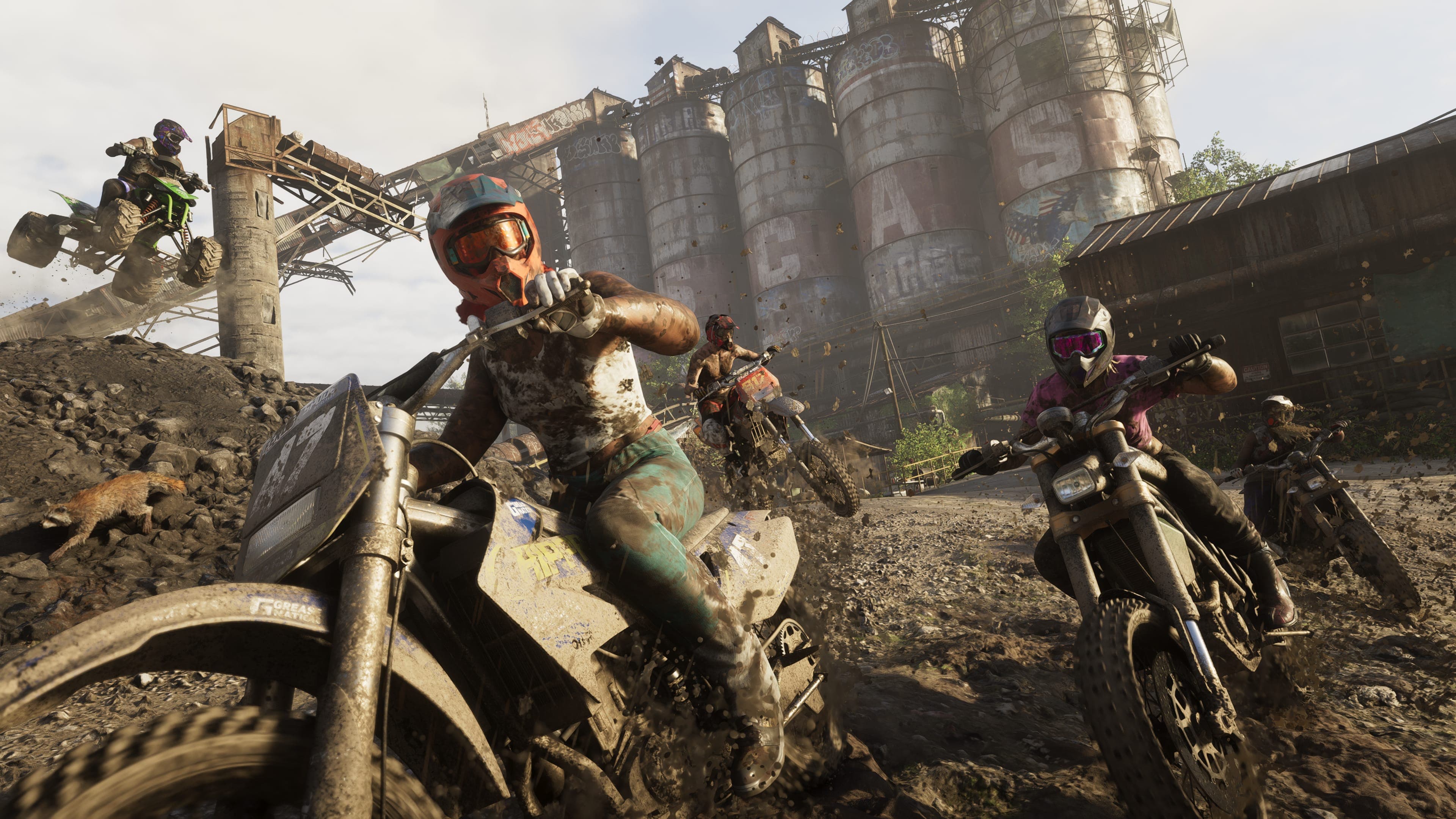 Riders on dirt bikes cutting through a derelict industrial yard on the edge of the park