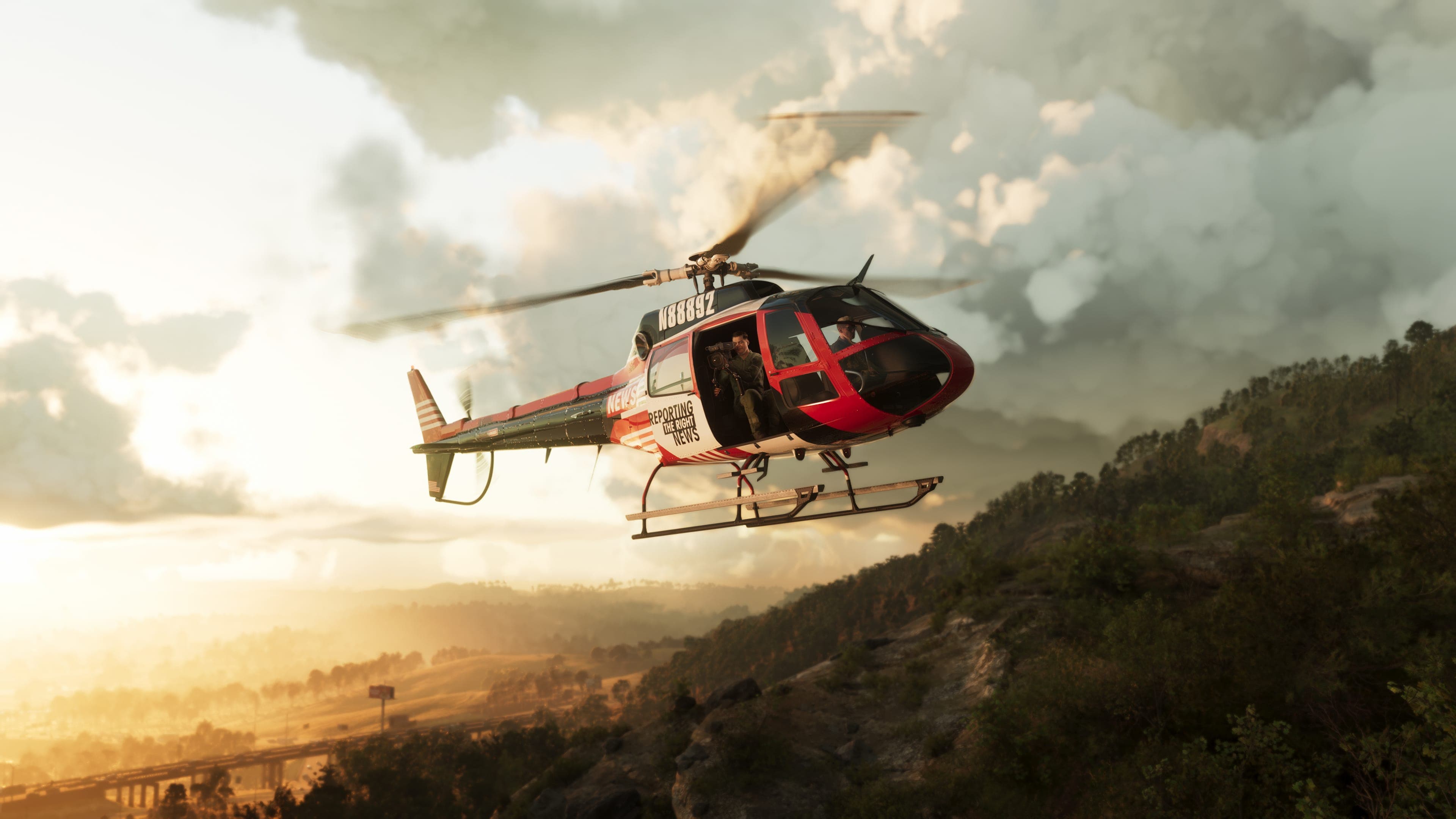 A red and white helicopter flying over forested hills at sunset