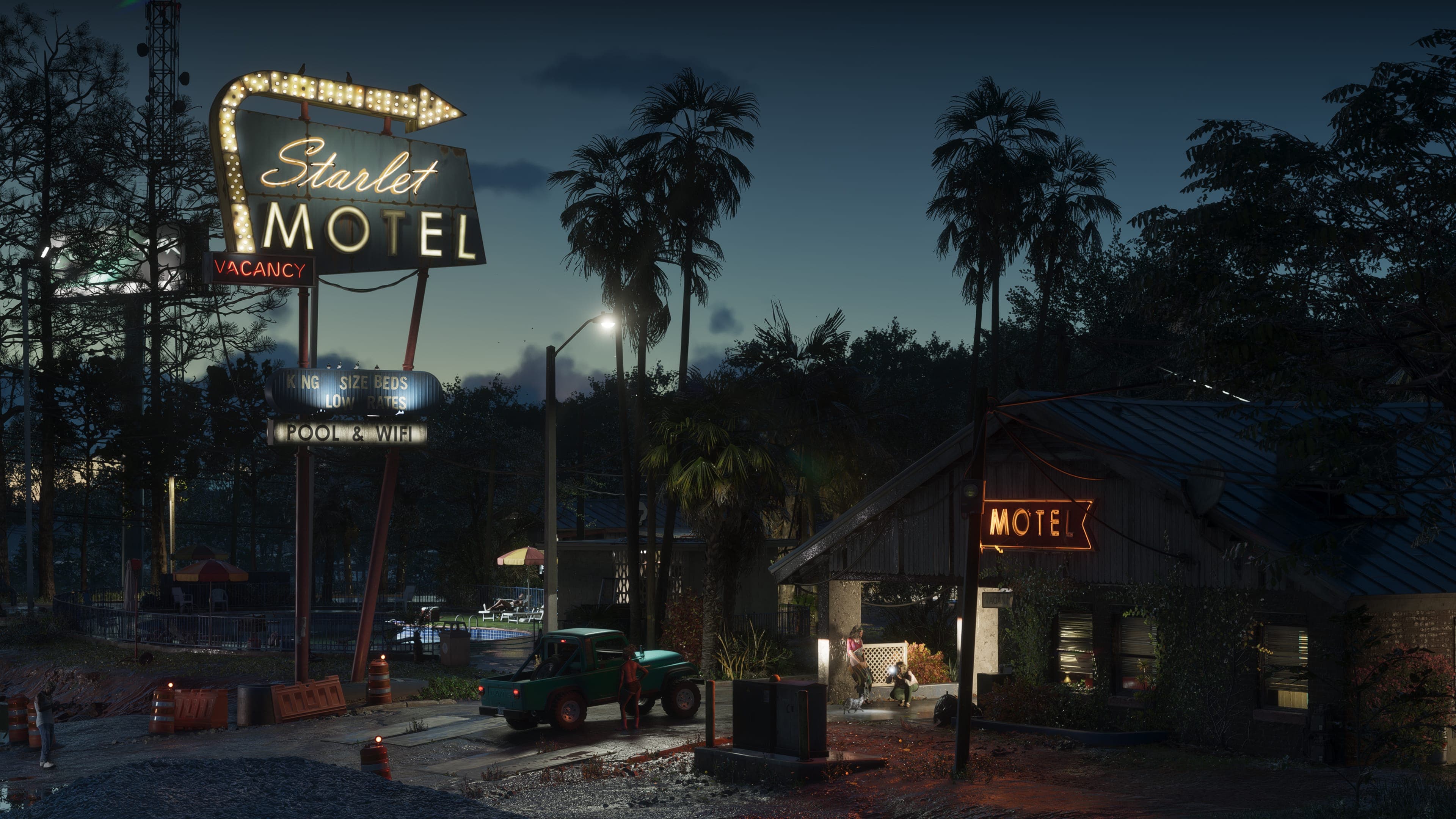 The Starlet Motel sign glowing at dusk over a low roadside motel and palms