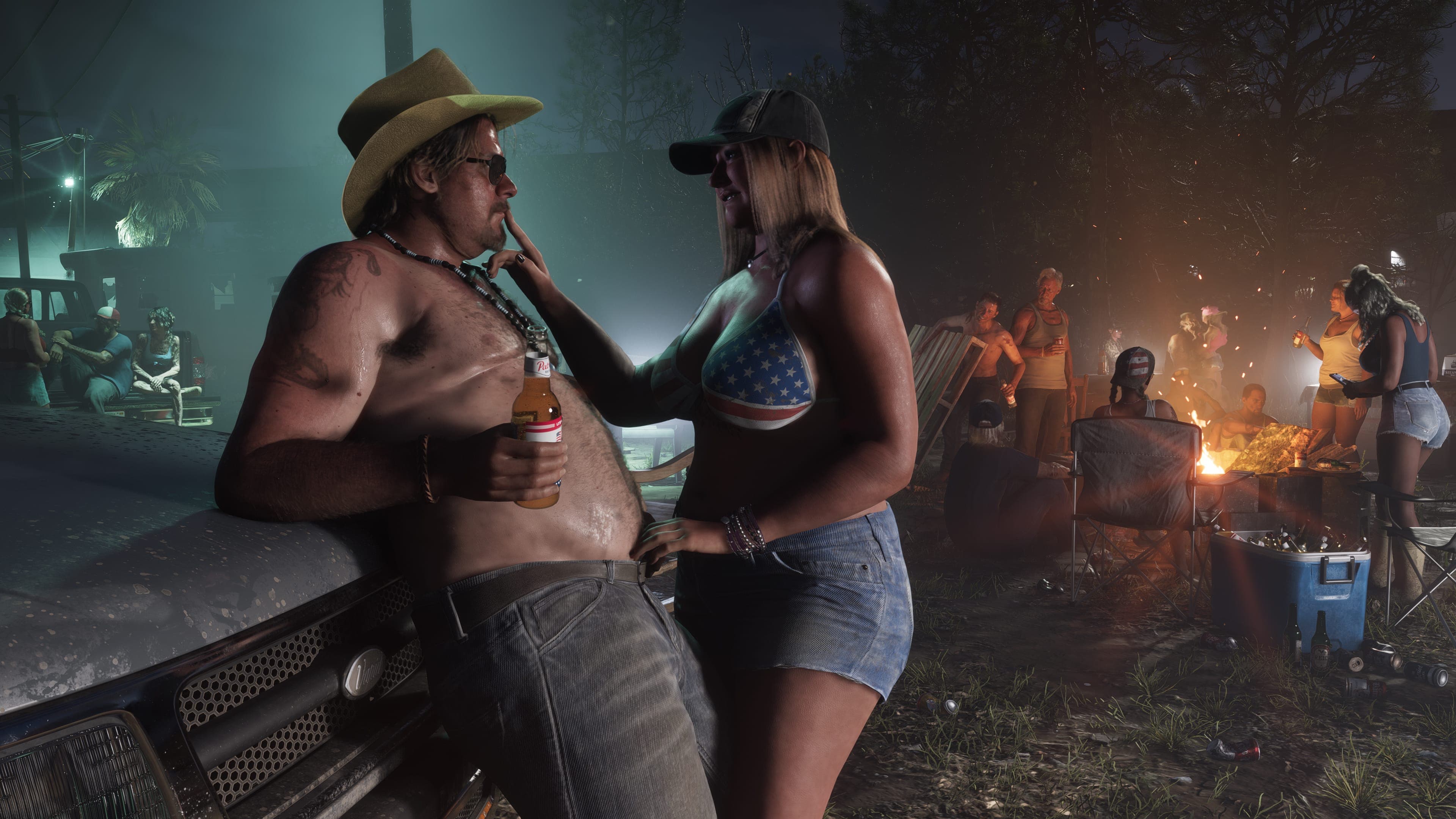 A night-time beach party around a bonfire, a couple talking in the foreground
