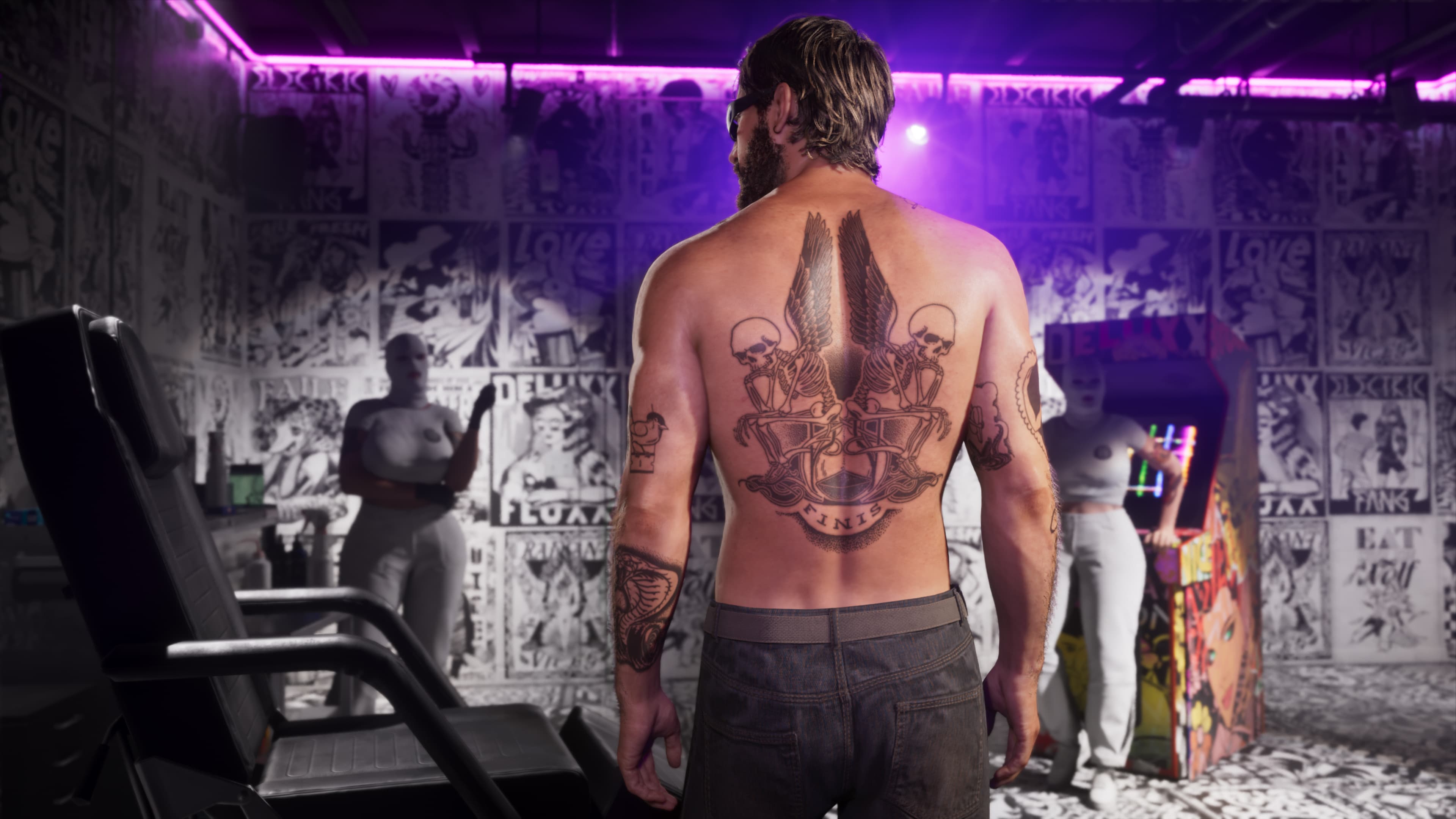 A man showing a large freshly inked back tattoo in a parlour lined with flash sheets