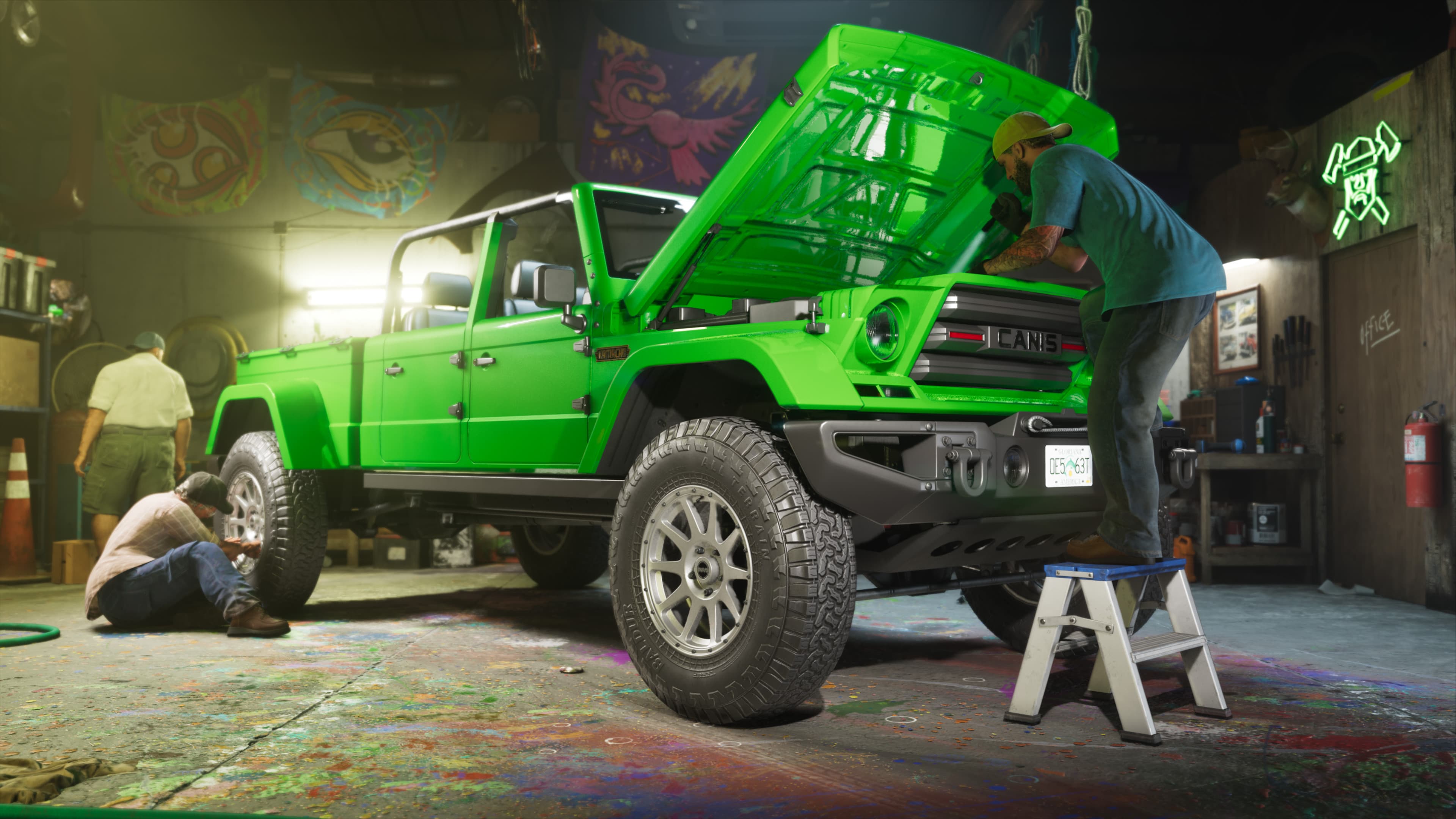 The green Canis truck up on axle stands in a workshop with its bonnet open