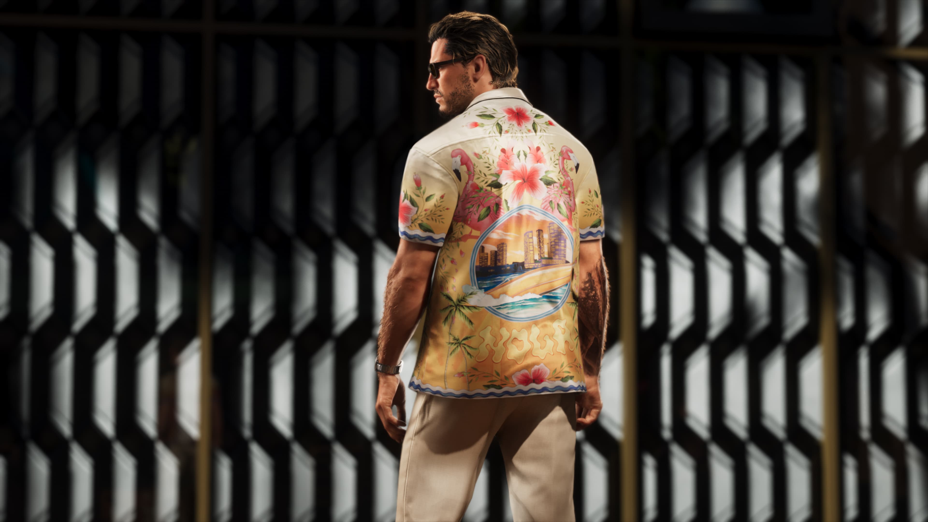 A man photographed from behind in a floral shirt against a metal grille