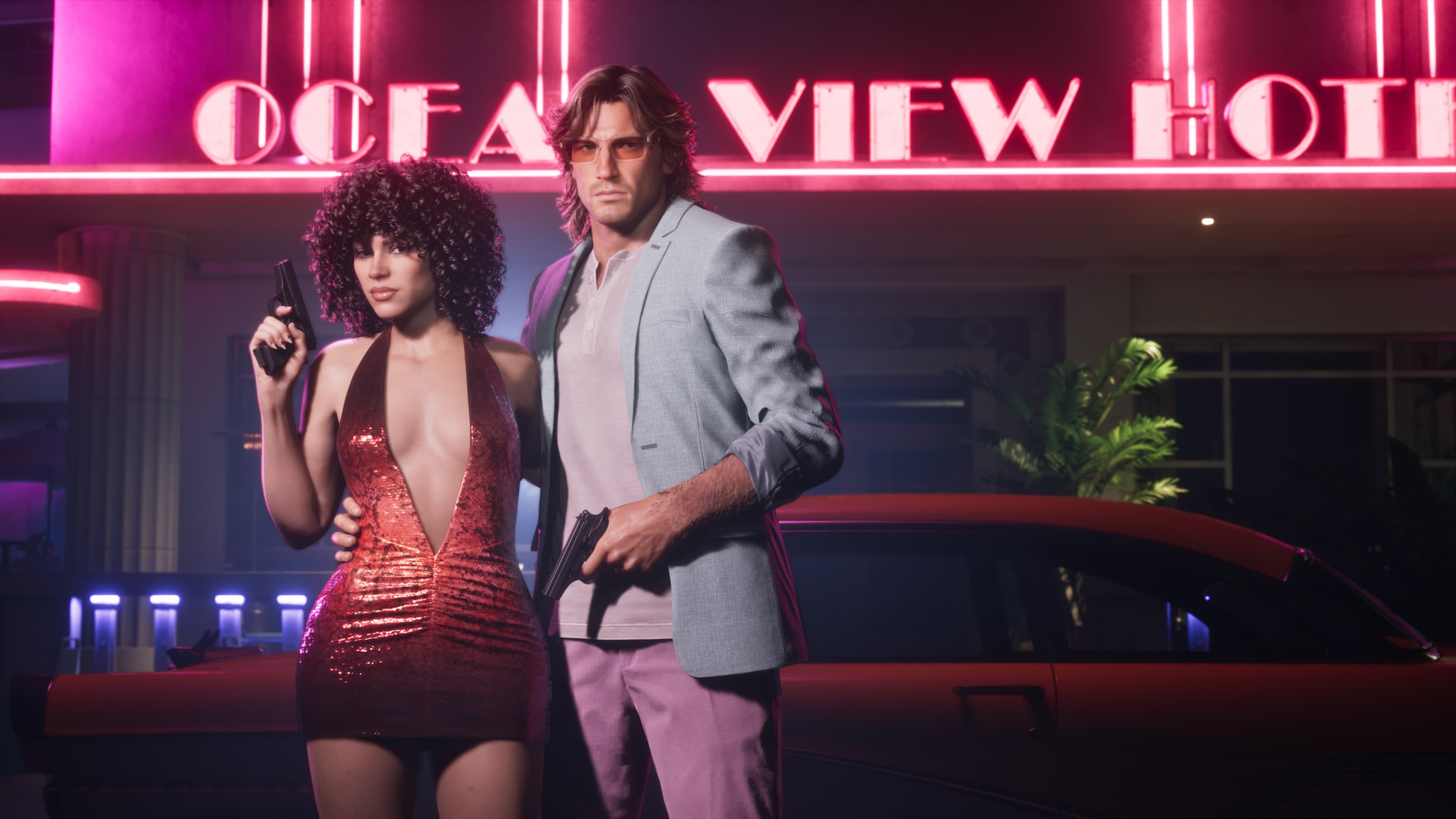 A couple in seventies eveningwear outside the neon Ocean View Hotel sign
